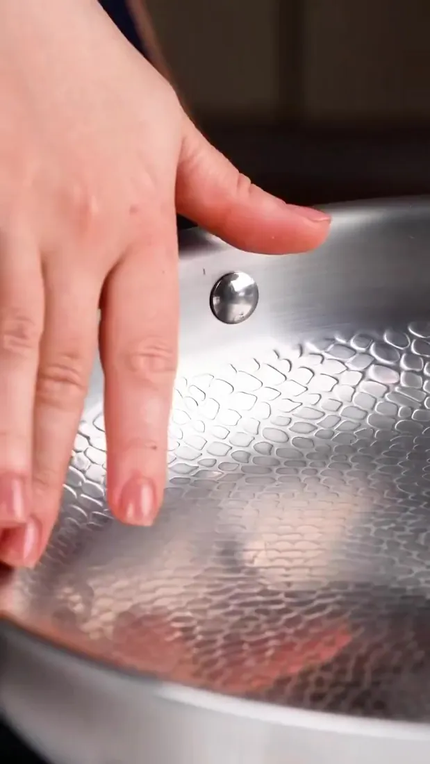 Home cook holding the Joyhnny titanium pan