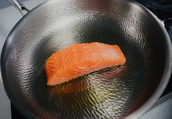 Salmon fillet cooking on the Joyhnny titanium surface
